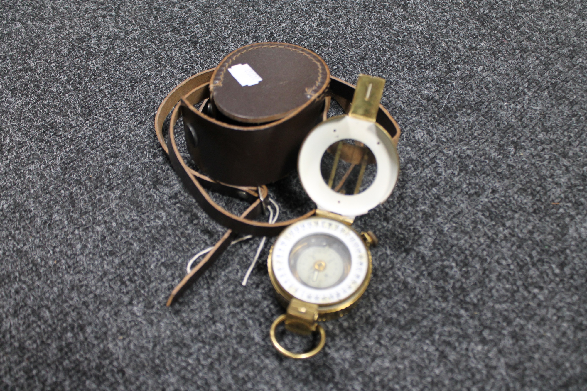 A brass cased nautical compass in leather pouch