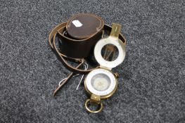 A brass cased nautical compass in leather pouch