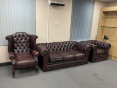 A three piece Chesterfield style oxblood button leather suite; wingback chair,