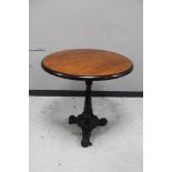 A circular topped pub table on cast iron tripod base.