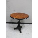 A circular topped pub table on cast iron tripod base.