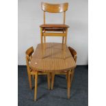 A mid 20th century melamine kitchen table and three chairs.