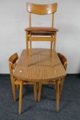 A mid 20th century melamine kitchen table and three chairs.