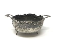 An ornate early 19th century twin handled silver bowl depicting a country scene CONDITION