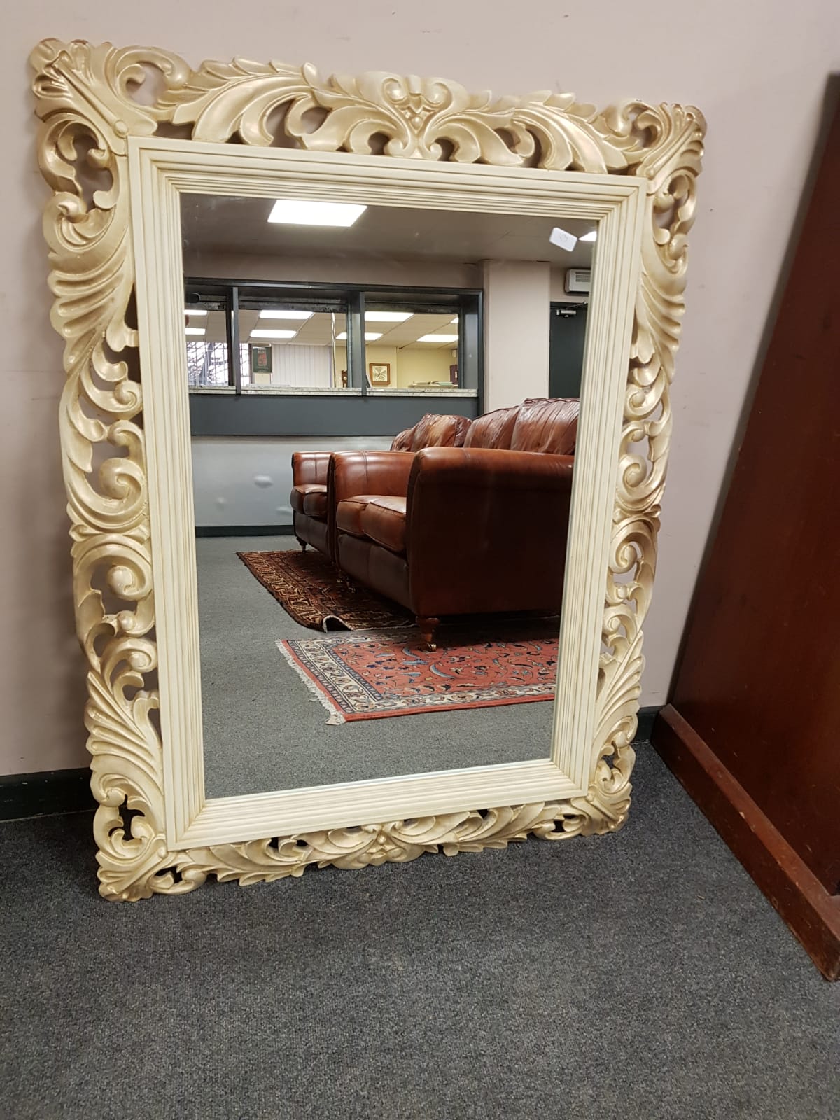 An ivory coloured framed mirror