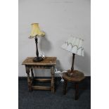 An antique oak stool, carved milking stool and two table lamps with shades.