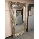 A large leaning framed mirror,