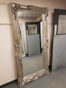 A large leaning framed mirror,