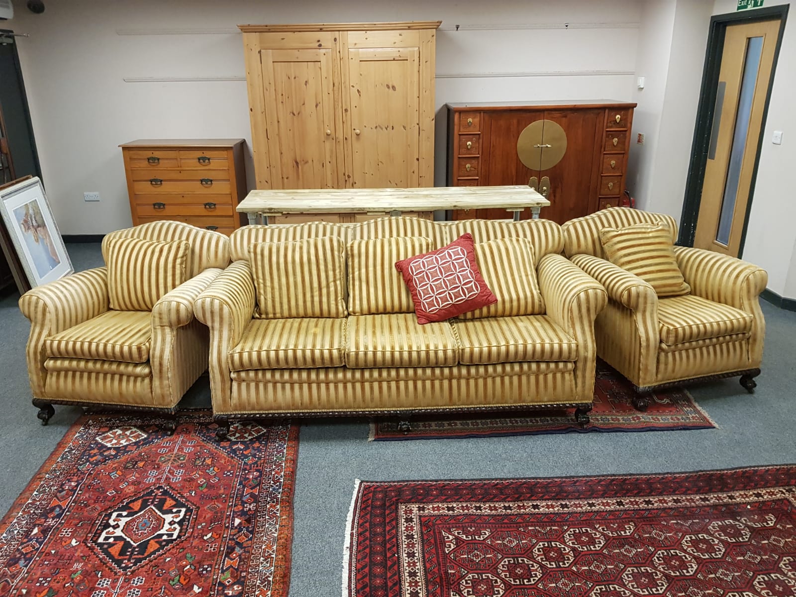 An Edwardian three piece lounge suite upholstered in golden striped fabric,