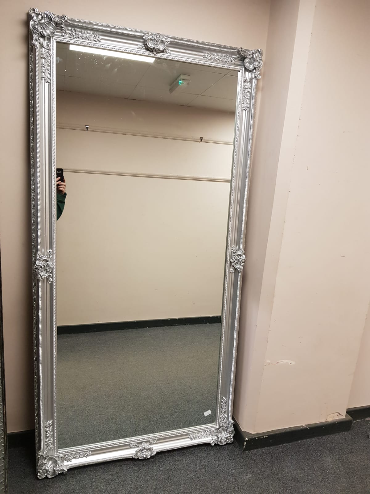 A chrome framed leaning mirror,