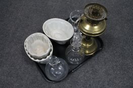 A tray of glass decanters, three vintage jelly moulds,