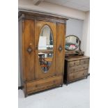 An Edwardian carved oak mirrored wardrobe together with four drawer dressing chest