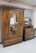 An Edwardian carved oak mirrored wardrobe together with four drawer dressing chest