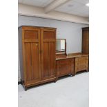 A three piece Edwardian mahogany bedroom suite comprising of gent's wardrobe,