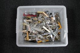 A plastic crate of assorted flatware