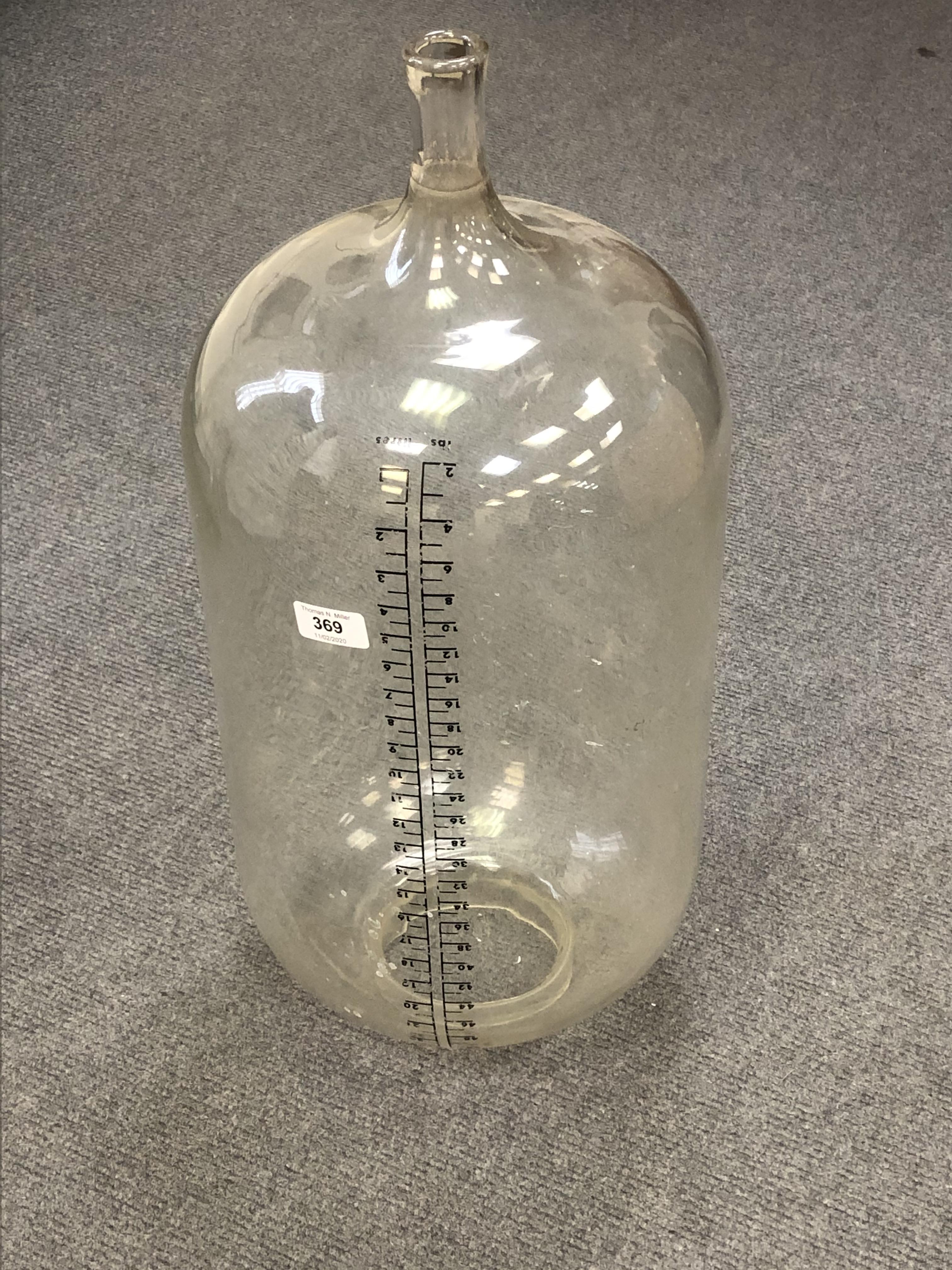 A large vintage glass measuring bottle,