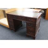 A mahogany twin pedestal writing desk fitted nine drawers and tooled leather inset panel.