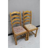 A pair of ladder backed dining chairs.