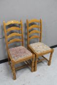 A pair of ladder backed dining chairs.