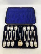 A Victorian cased set of twelve silver spoons, tongs and matching caddy spoon.