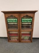 An Edwardian and later oak display cabinet "Ogden's Cigarettes",