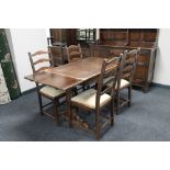 An Ercol refectory dining table and four ladder back chairs.