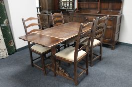 An Ercol refectory dining table and four ladder back chairs.