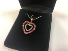 A 10ct gold ruby and diamond heart pendant on silver chain