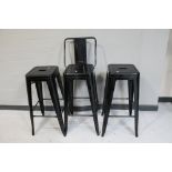A pair of metal French style cafe stools together with a bar stool