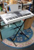 A Yamaha PSR-295 electric keyboard with lead on stand.