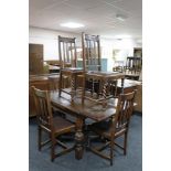 An early 20th century oak pull out table and six rail back chairs.