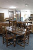 An early 20th century oak pull out table and six rail back chairs.