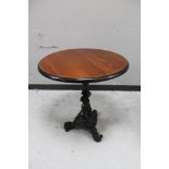 A circular topped pub table on cast iron tripod base.