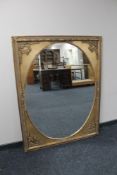 A Victorian style gilt framed overmantel mirror with oval glass.