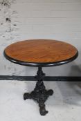 A circular topped pub table on cast iron tripod base.