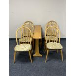 An Ercol elm narrow drop leaf table and six dining chairs.