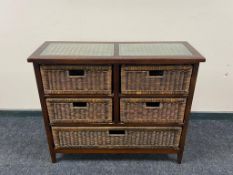 A contemporary glass topped chest fitted with five wicker drawers