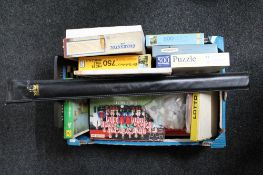 A box of vintage board games and puzzles, cased snooker cue,