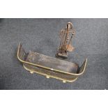 An antique brass fender together with a cast iron three piece companion set on stand
