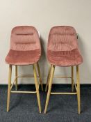 A pair of contemporary breakfast bar chairs on metal legs upholstered in pink fabric