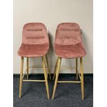 A pair of contemporary breakfast bar chairs on metal legs upholstered in pink fabric