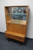 A mid century teak sliding glass door bookcase fitted with cupboard and drawer beneath