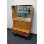 A mid century teak sliding glass door bookcase fitted with cupboard and drawer beneath