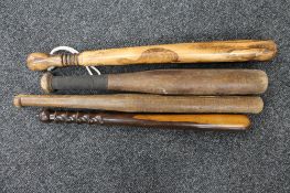 An early 20th century truncheon together with three wooden rounders bats CONDITION