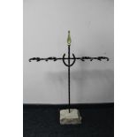 A cast metal horse shoe boot stand on concrete base