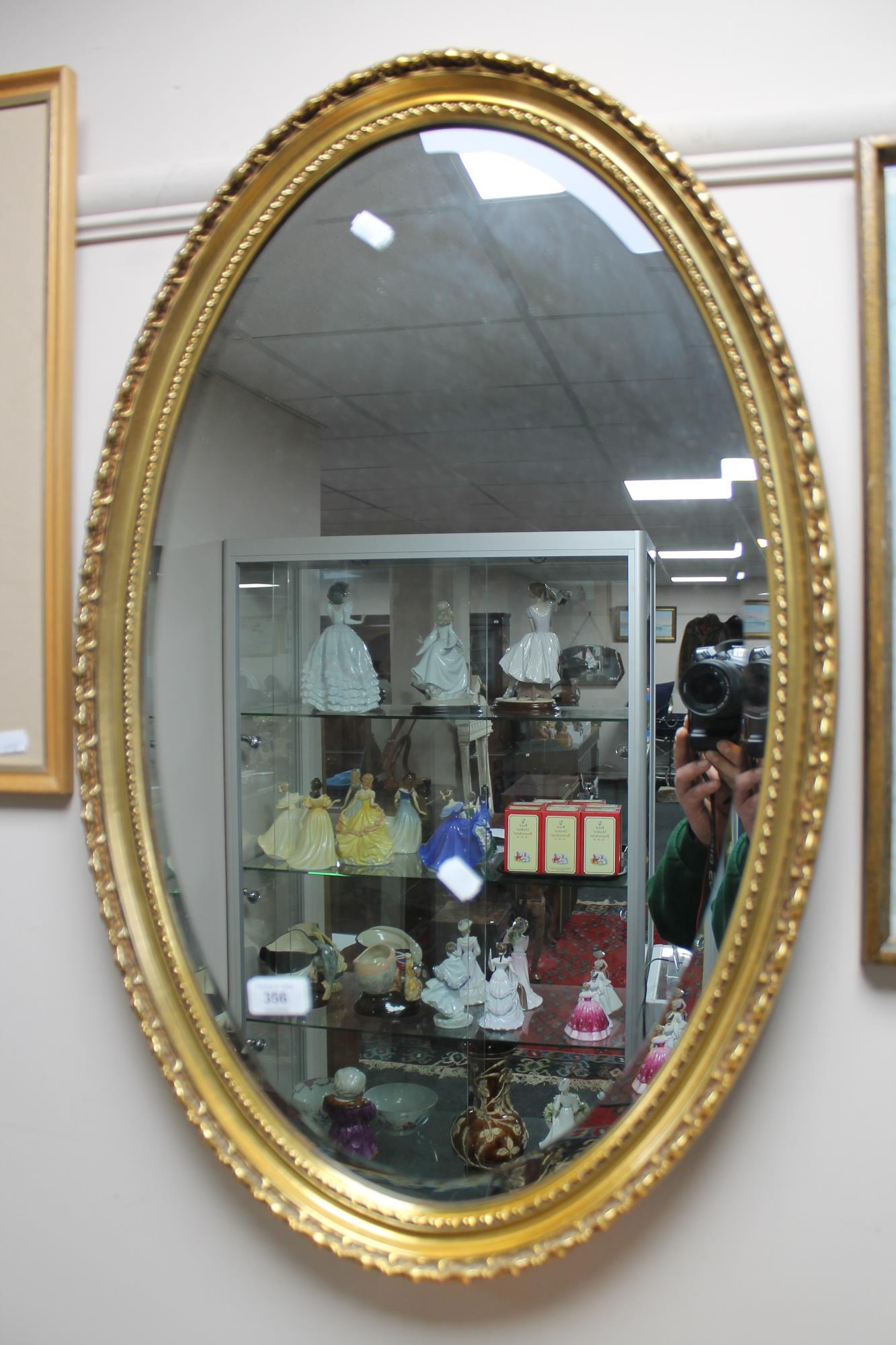 An oval gilt framed bevelled mirror