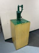 A cast iron pump attached to a metal cabinet