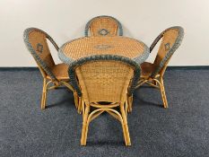 A circular bamboo and wicker dining table together with four chairs