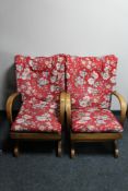 A pair of mid century teak framed rocking chairs