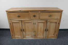 An Edwardian pine four door sideboard fitted with three drawers